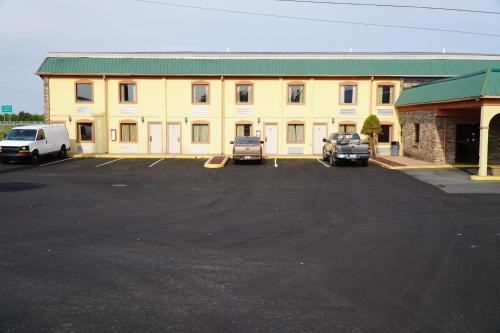 a large yellow building with cars parked in a parking lot at Richmond - Quality Quarters Inn in Richmond