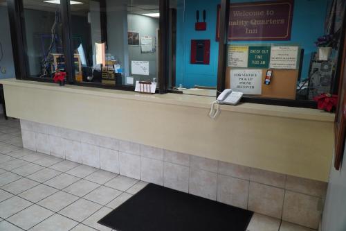 a cashier counter in a store with a sign in the window at Richmond - Quality Quarters Inn in Richmond