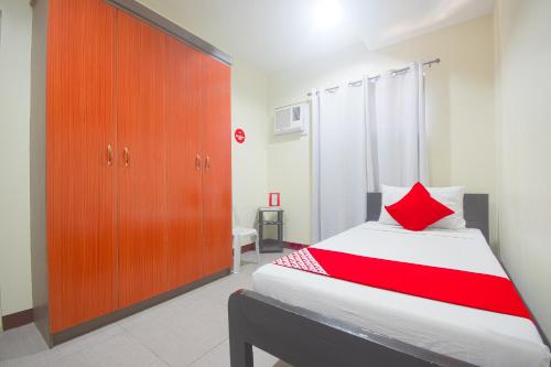 a bedroom with a bed and a wooden cabinet at OYO 567 Blue Horizon Hostel in Dumaguete