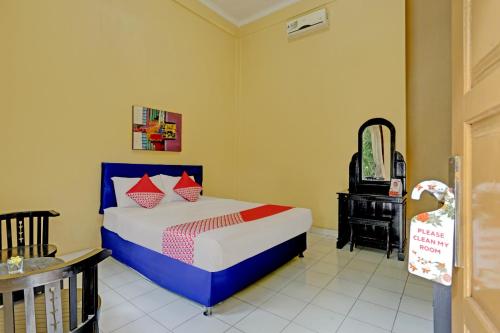 a bedroom with a bed and a mirror and a crib at OYO 3096 Hotel Dewi Warsiki Near Gilimanuk Port in Gilimanuk