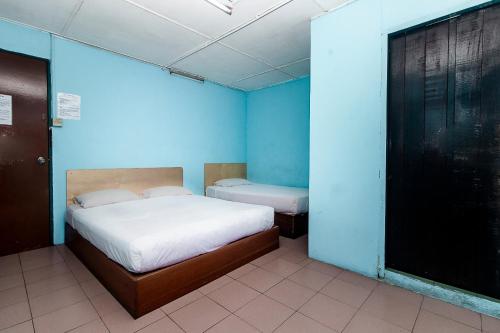a blue room with a bed and a toilet at Hotel O Gold Star Hotel in Sibu
