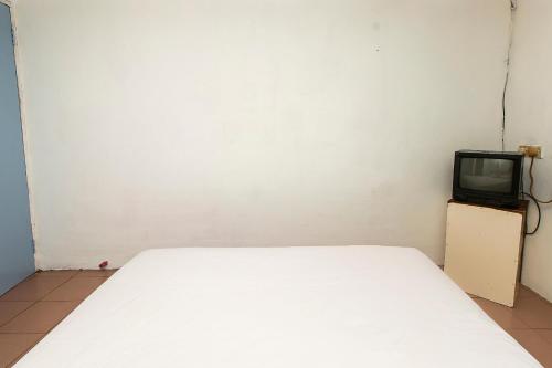 a bedroom with a bed and a tv on a cabinet at Hotel O Gold Star Hotel in Sibu