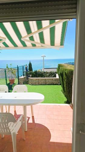 a table and chairs on a patio with a view of the ocean at Ara Bela Duplex con jardin in Peniscola