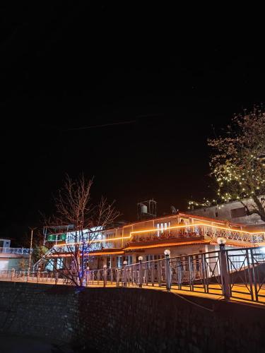 a building with lights on a bridge at night at The Whitegrove Retreat in Mukteswar