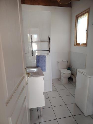 a white bathroom with a toilet and a sink at Gîtes des Deux Vallées La Borieta du Causse - Rocamadour in Rocamadour