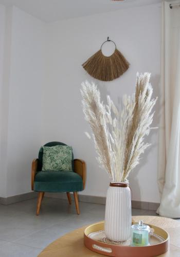 a vase sitting on a table in a room with a chair at Les Hauts du Port-appartement élégant et central in Bonifacio