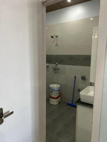 a bathroom with a shower and a toilet and a sink at The Whitegrove Retreat in Mukteswar