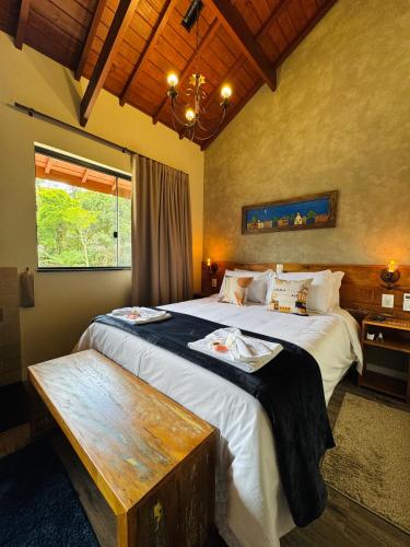 a bedroom with two beds and a wooden table at Villa Tirol - Monte Verde in Monte Verde