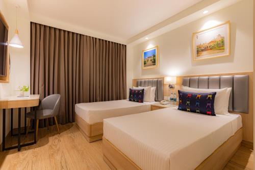 a hotel room with two beds and a desk at Keys Prima by Lemon Tree Hotels, Pimpri, Pune in Pune