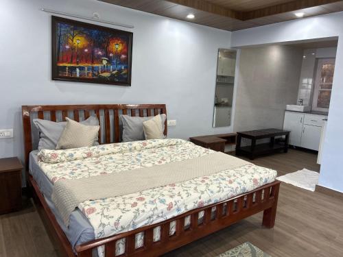 a bedroom with a bed with a painting on the wall at The Whitegrove Retreat in Mukteswar