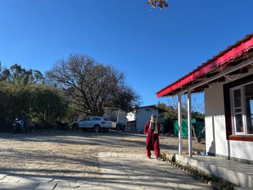 a woman is standing outside of a building at The Whitegrove Retreat in Mukteswar