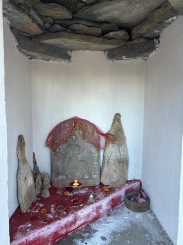 a room with a fireplace with two statues of chickens at The Whitegrove Retreat in Mukteswar