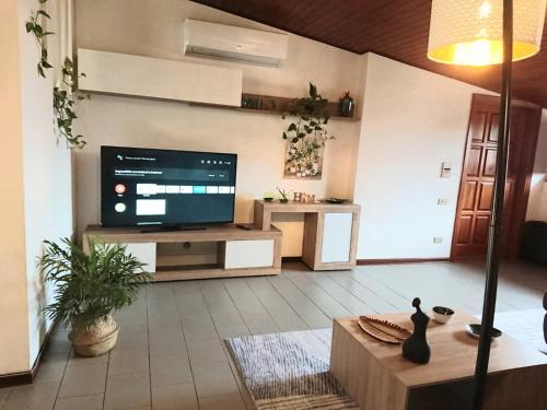 Una sala de estar con un televisor de pantalla plana en una pared. en Vacanze in Mansarda, en Oristano