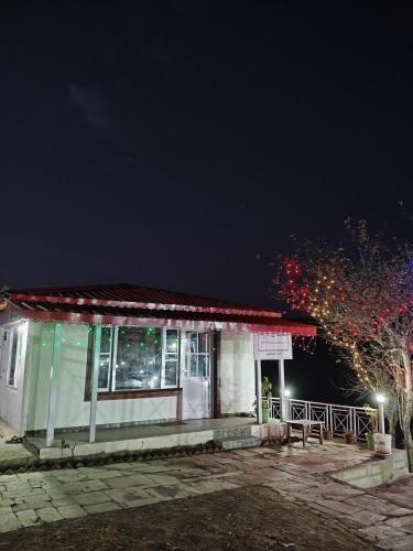 a small building at night with christmas lights at The Whitegrove Retreat in Mukteswar