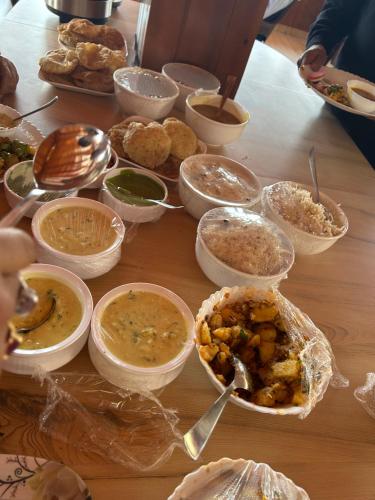 a table topped with bowls of food and dips at The Whitegrove Retreat in Mukteswar