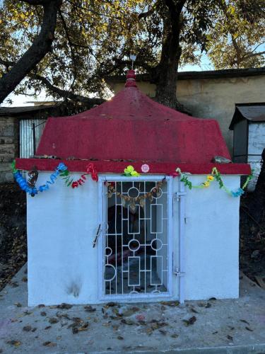 a small dog house with a red roof at The Whitegrove Retreat in Mukteswar