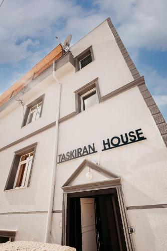 a white building with a sign that reads tashian house at Taşkiran house in Ortahisar
