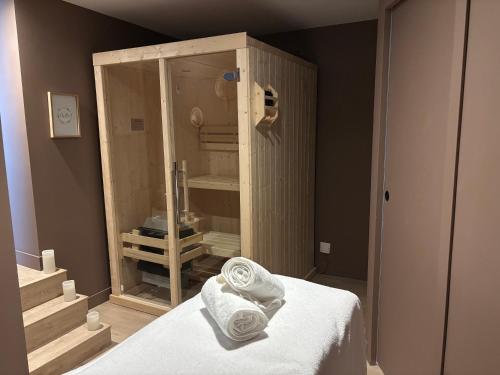 a bedroom with a shower with towels on a bed at Suite Banjar-Luxe,Balnéo & Sauna in Saint-Aubin-dʼAubigné