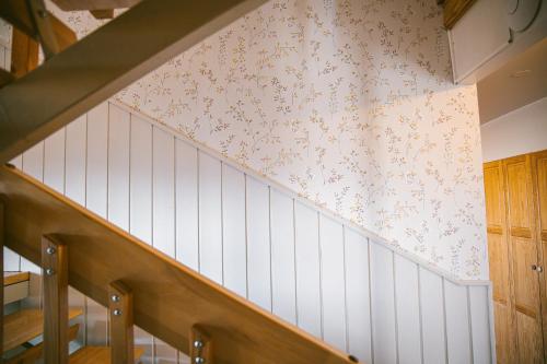 a staircase with white and pink wallpaper at Milli Vina Guesthouse in Borgarnes