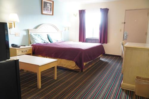 a hotel room with a bed and a window at Richmond - Quality Quarters Inn in Richmond