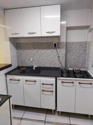 a kitchen with white cabinets and a sink at Do Alto Residencial in Curitiba