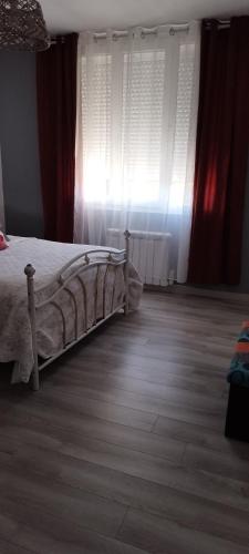 une chambre avec un lit et une fenêtre avec des rideaux dans l'établissement Charmante maison 6/7 personnes., à Olonne-sur-Mer