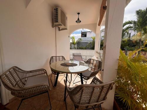 a patio with a table and chairs on a balcony at Studio cosy avec piscine dans une villa in Saint-Denis