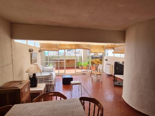 Una cocina y una sala de estar con mesa y sillas. en Departamento en Playa Varese, en Mar del Plata