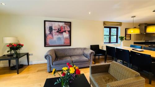 a living room with a couch and a kitchen at Hustyns Hotel in Wadebridge