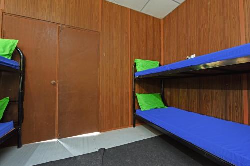 a bunk room with blue bunk beds and wooden walls at Hotel O Otternest @ Gunung Pulai 2 in Pontian Besar