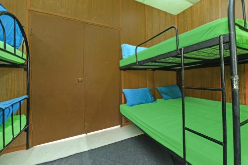 a room with two bunk beds and a door at Hotel O Otternest @ Gunung Pulai 2 in Pontian Besar