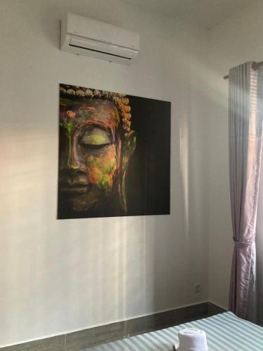 a painting of a head hanging on a wall at Lotus Haven Villa in Siem Reap
