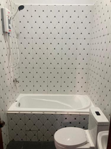 a bathroom with a white tub and a toilet at Lotus Haven Villa in Siem Reap