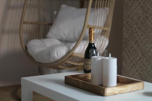a bottle of champagne and two rolls of toilet paper on a table at Suite Banjar-Luxe,Balnéo & Sauna in Saint-Aubin-dʼAubigné