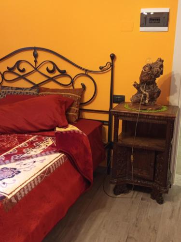 a bedroom with a bed and a nightstand next to a bed with a red at B&BLe Tre Gemme in Montechiarugolo