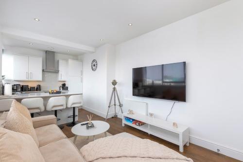a living room with a couch and a tv on a wall at Luxury 2-Bed Hove Suite Escape in Brighton & Hove