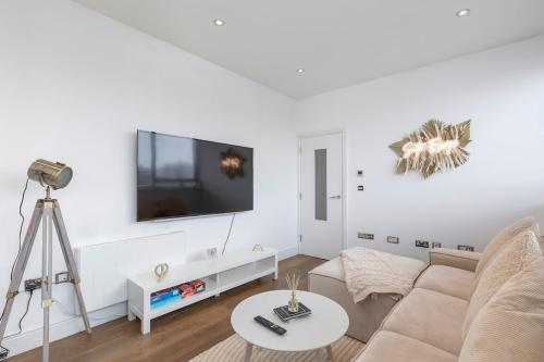 a white living room with a couch and a tv at Luxury 2-Bed Hove Suite Escape in Brighton & Hove