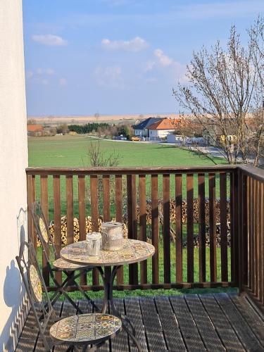 einen Tisch auf einem Balkon mit einem Tisch auf einer Bank in der Unterkunft Appartement Sonnblick in Breitenbrunn
