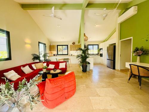 a living room with a red couch and a table at Villa Boheme O Lagon in Le François