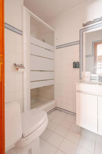 a white bathroom with a toilet and a sink at Casa da Joana in Mirandela