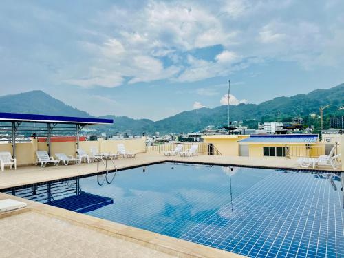 a swimming pool on the roof of a building with mountains at Patong best location Apartments, 2 bedrooms in Patong Beach