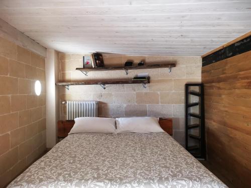 a bed in a room with a brick wall at APN Holiday Home in Altamura