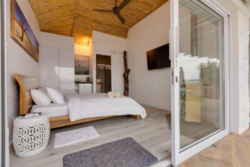 a bedroom with a bed and a sliding glass door at Enso Botanico Boutique Villa, Kosmos in Hartbeespoort