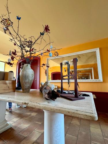 a room with a table with a vase and a mirror at B&BLe Tre Gemme in Montechiarugolo