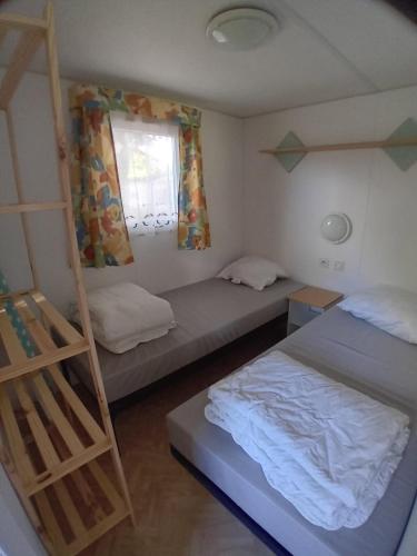 - une petite chambre avec 2 lits et une échelle dans l'établissement Mobil Home bord de mer CAMPING LES TAMARIS, à Saint-Pierre-dʼOléron