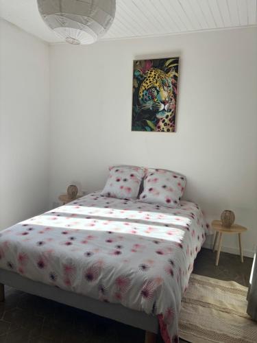 a bedroom with a bed and a painting on the wall at Écrin paisible in Vergèze