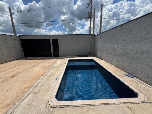 an empty swimming pool in a building with a door at Maggi Residence in Batatais
