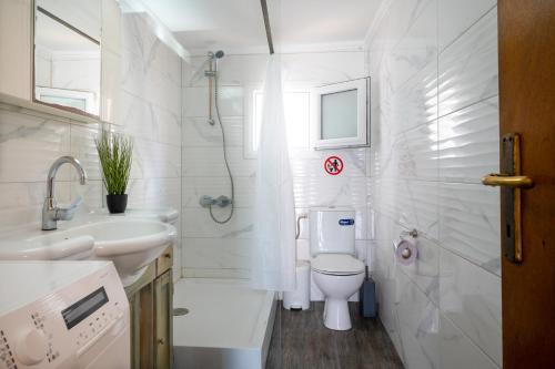 ein weißes Badezimmer mit Toilette und Waschbecken in der Unterkunft Villa МareMaria in Nea Kallikratia