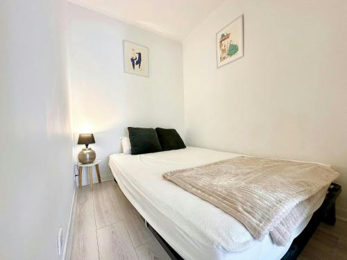 - une chambre blanche avec un lit et une couverture dans l'établissement Charmant 2 pièces Centre cannes proche palais, à Cannes