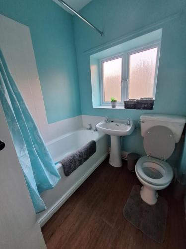 a bathroom with a tub and a toilet and a sink at Carlcroft Cottage in Alwinton